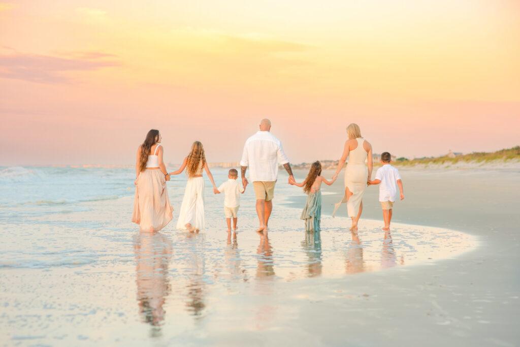 A family of 7 walks in the surf in front of a beautiful sunset in Myrtle Beach, South Carolina